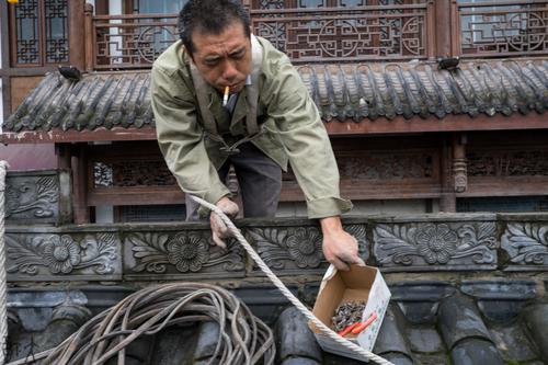 一位工人在修补被水淹的商铺